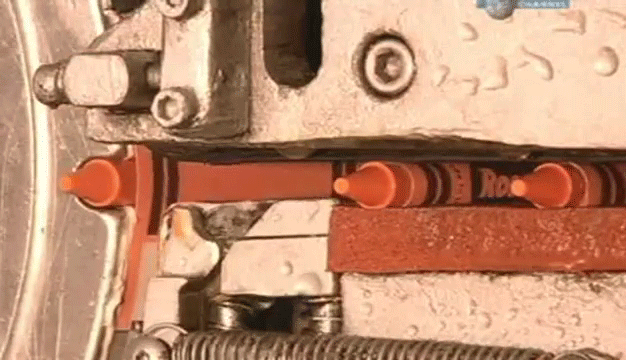 Crayons being wrapped by machinery